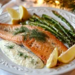 Steelhead trout served with roasted asparagus and dill sauce.